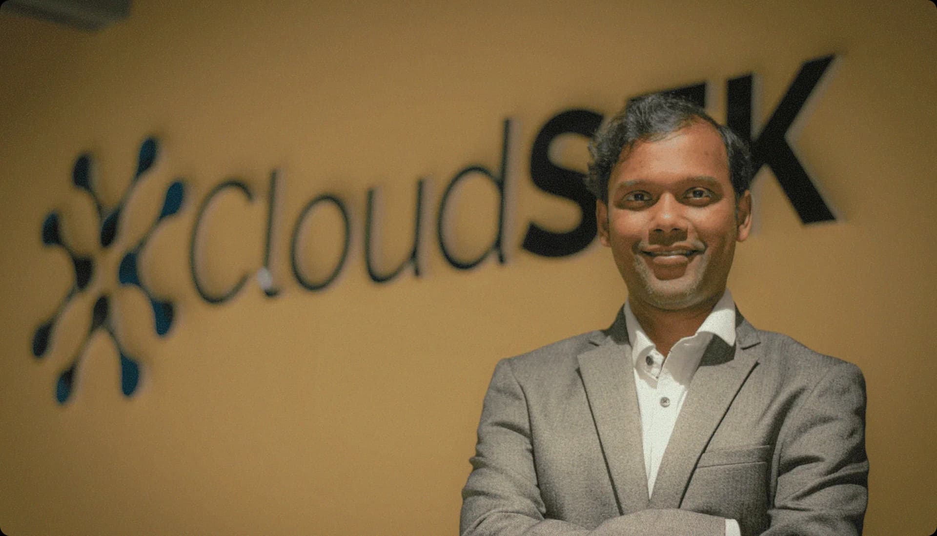 Rahul Sasi, CloudSEK founder, in front of CloudSEK office sign