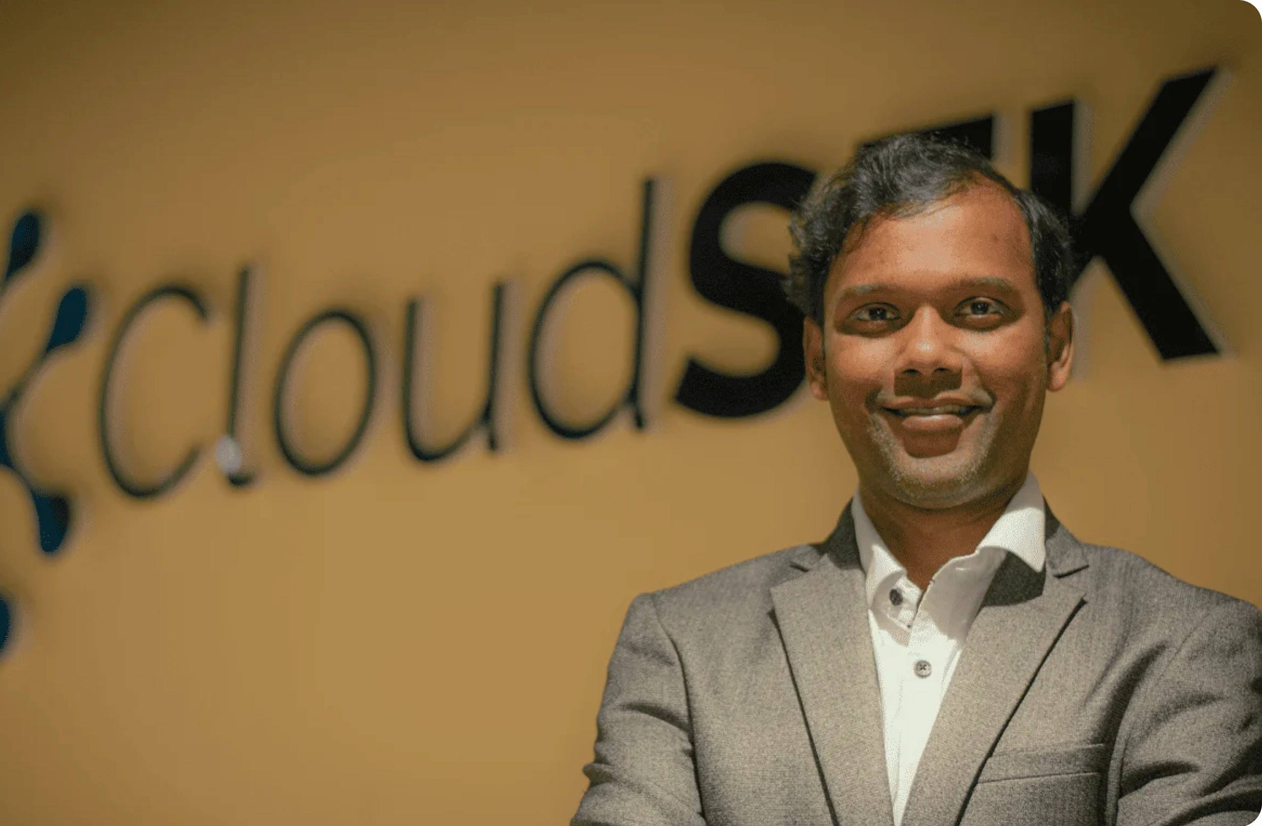 Rahul Sasi, CloudSEK founder, in front of CloudSEK office sign